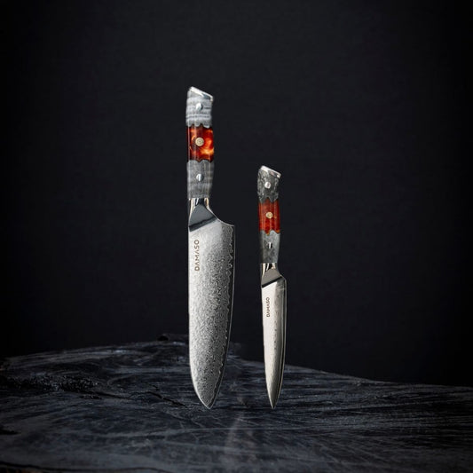 Messerset Red Ash DAMASO – Japanisches Santoku 17,8 cm und Allzweckmesser 12,5 cm aus Damaststahl mit VG10 Stahlkern vor dunklem Hintergrund